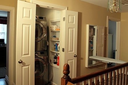 tiny hallway laundry closet with stacked washer and dryer and wall cubbies, The Yummy Life